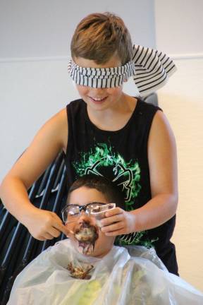 Jacob Evans of Stockholm blindfolded feeds George Orellana of Wantage pudding.