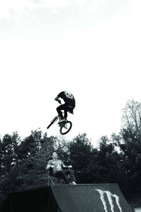Rob Armour jumping over a Newton resident, Tom Mattice at the BMX show in the Wal-Mart parking lot on sunday.