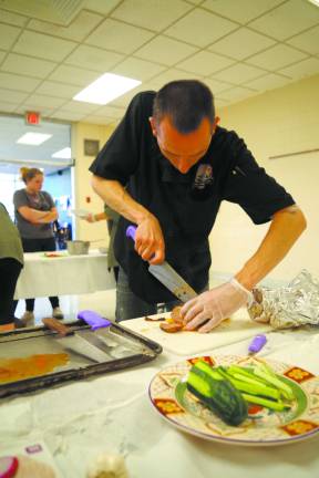 Vincent Jurczyszyn from Smokey's Brick Oven Tavern slices some turkey into bite-sized pieces.
