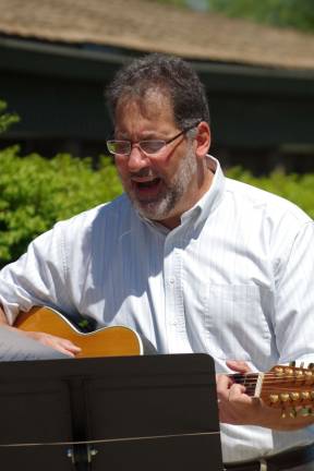 Pastor Nik Fontana of the Faith With Love Fellowship at the McAfee Bible Church closes the service by leading the group in singing "America the Beautiful" and "God Bless America."