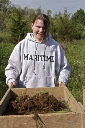 Middle schooler Alyssa Carcich works the sifter looking for artifacts that may be hidden in the dirt and grass.
