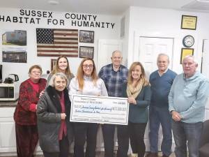 Emily Bowden, fourth from left, of the Sussex County Association of REALTORS presents a check for $12,000 to the board of directors of the Sussex County Habitat for Humanity in Newton. From left are Jan Miglin, Carolyn King, Pam Vreeland, Bowden, board president Ken Landrud, Sandy Gardner, Jim Ciaravolo and Wade Abbott. (Photo provided)