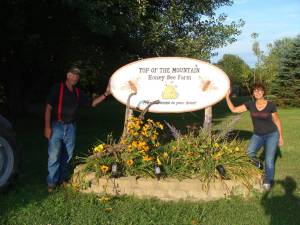 John and Donna Coco pose at the entrance to their 10-acre honey bee farm.