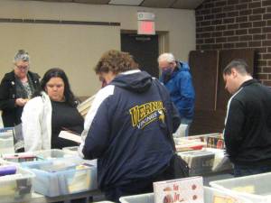 Library patrons browse and choose books at a substantial discount.