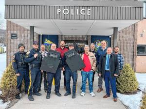 <b>Noel Albert, owner of Damon Associates insurance agency, donates two police ballistic shields, worth a total of $10,000, to the Vernon Township Police Department. From left are police Sgt. Harry Russo, Cpl. Colton Rembish, Capt. Jason Haw, Patrolman Trevor Krupinski, Lt. Daniel Young, Patrolman Jake Costello, Noel Albert, Cpl. Jay Mangano, Chief Dan Young, Mayor Anthony Rossi and Sgt. Ron Koumaras. (Photo provided)</b>