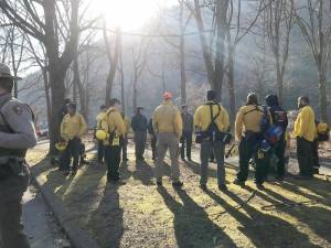 Wildland firefighters gather at Kittatinny Point for a morning briefing before heading up Mount Tammany.