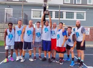 Team Smalley captain John Smalley raises the Sparta Summer Basketball League championship trophy high during a team portrait after their victory over Team Tobin.