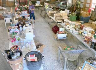 Snufftown Garden Club President Rose Wolverton looks over some of the many donations from Snufftown members that will be available at the yard sale.