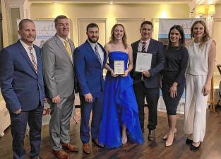 <b>Chloe DeBonta, center, a senior who plays field hockey, basketball and lacrosse, represents Vernon Township High School at the annual Pass it Along Scholar Athlete banquet at the Lake Mohawk Country Club. With her, from left, are lacrosse coach Steve Carlson, athletic director Bill Foley, trainer Matt McKowen, field hockey coach Kieran Killeen, Principal Lindsay Leduc and basketball coach Stephanie DePiano. (Photo provided)</b>