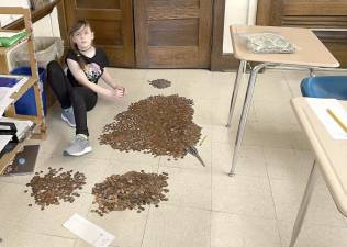 A Sussex Middle School student helps count pennies.
