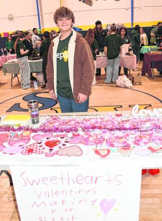 <b>Sage Lauffenburger stands by his Valentine's Making Kits table.</b>