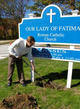 PHOTY BY CHRIS WYMAN Our Lady of Fatima parishioner Tim Morrissey is shown starting to bury a time capsule on June 25 to commemorate the church's 50th anniversary. The capsule will be dug up in 25 years.