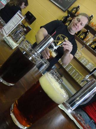 Erik Hassing pours samples of Ravol American amber ale and three-ball porter.
