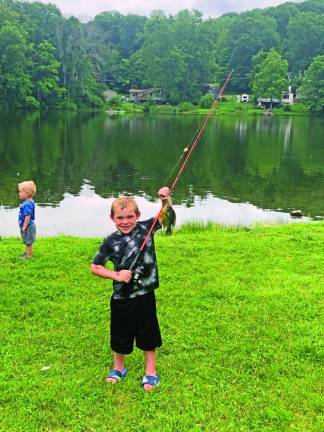 Logan Cosh, 6, of Wantage holds up a sunfish he caught. He caught the most fish among the children.