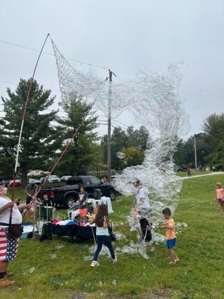 Children play with bubbles at the Vernon Street Fair.