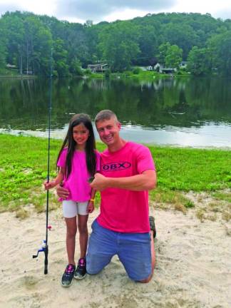 Elizabeth Cerutti, 7, of Wantage and her father, Ben, pose with a sunfish. She caught the smallest fish in the children’s category.