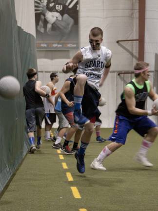 A member of the Finger Licking Goods jumps to avoid being hit with a dodgeball.