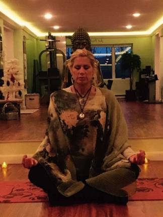 Catherine Stone, owner of Just Breathe Wellness Studio, instructs a meditation class.