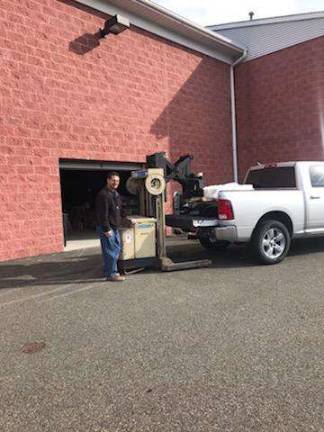 Kellstrom demonstrates how, with the use of his forklift, he can transport product into a customer's vehicle right from his warehouse.