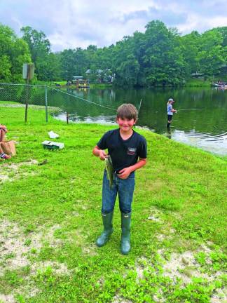 Hudson DeWaal, 10, of Wantage shows off the largemouth bass he caught. He caught the largest fish among children age 10 and younger.