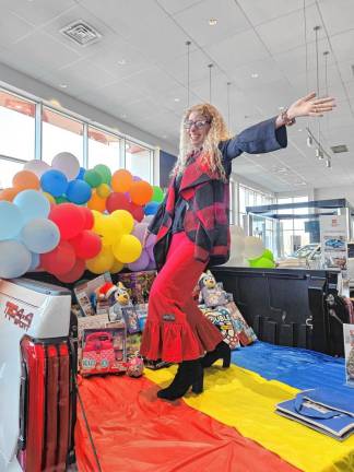 Michele Wolf poses at the Center for Prevention &amp; Counseling’s first Stuff the Truck event in December with World Auto Group Toyota and Subaru of Newton. Gifts donated by the dealership’s employees, management and customers were distributed at the center’s holiday celebration. (Photos provided)