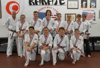 PHOTO BY VERA OLINSKI From left, Sensei Thomas Shull, Elite Squad, and Sensei Monica Rolando pose after graduation.