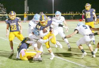 Vernon running back John Rosado moves the ball forward with Sparta defenders in hot pursuit.