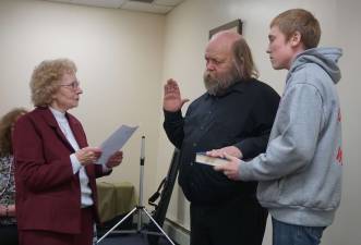 Photo by Vera Olinski Sussex Borough Mayor Katherine Little, left, administers the Oath of Office to newly appointed Councilman Albert Decker as his grandson, Albert Demarest, holds the bible.