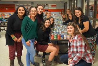 Some of the &quot;Fill the Bus 2018&quot; committee poses in front of collected food.