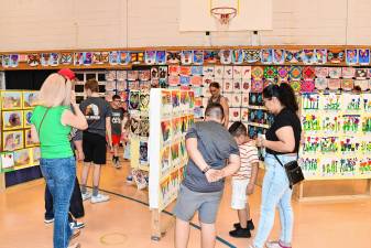<b>Residents look at student artwork during Artstanding 2025 on Friday, May 16 at Lounsberry Hollow Middle School in Vernon. The annual event highlights the work of students in grades K-12 in the visual, performing and practical arts. (Photos by Maria Kovic)</b>