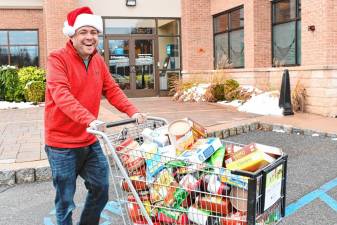 <b>Steve Allan of radio station 102.3 WSUS brings donated food to a Sussex County Skylands Ride bus Friday, Nov. 22 at the Provident Bank in Sparta. (Photo by Maria Kovic)</b>