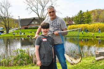 Lucas Fish poses with his father, Rob, who is holding a net with the fish that Lucas caught at the Fishing Derby on Sunday, April 28 in Vernon. That was the largest fish caught at the derby. (Photo by Maria Kovic)