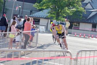 A cyclist rounds a corner at a previous Pass It Along Triathlon event.