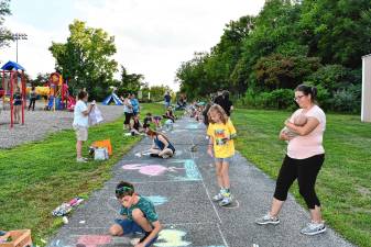 <b>Residents draw on the walk during the Sidewalk Chalk Art Festival on Thursday, Aug. 14 at Maple Grange Park in Vernon. (Photos by Maria Kovic)</b>