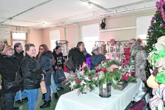 <b>Visitors peruse the tables at the Lusscroft Holiday Benefit on Saturday.</b>