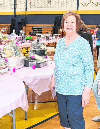 <b>Joann Lisa of Vernon stands in front of a table.</b>