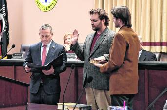 <b>U.S. Rep. Josh Gottheimer, left, swears in Carl Contino onto the Vernon Township Council. Contino, 26, is the township's youngest councilman.</b>