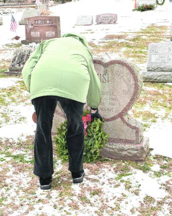<b>Paula Kuzicki places a wreath in honor of James Rannazzisi, who served in the Korean War.</b>