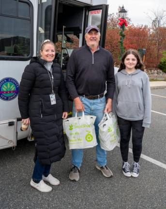 MIke Vrabel drops off donations Friday. Posing with him are Stuff the Bus volunteers Rebecca, left, and Allie Ismail.