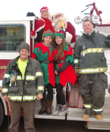 Santa &amp; Troupe on fire truck flanked by firemen Dan VanderBerg (driver) and Ryan Hanshaw.