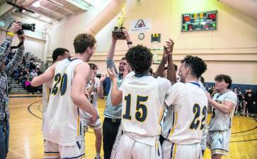 Coach Connor Healy holds up the trophy after the Vikings win their first Hunterdon/Warren/Sussex championship. (Photos by John Hester)