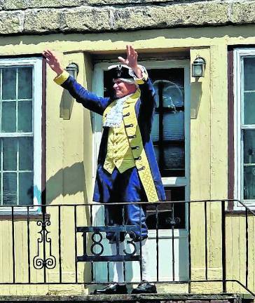 <b>A reenactor waves to the crowd.</b>