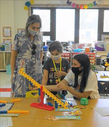 Paola and her mom use the Number Balance with teacher Kristina Megnin (Photo by Vera Olinski)