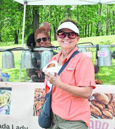 <b>Janet Smith of Vernon eats an empanaada.</b>