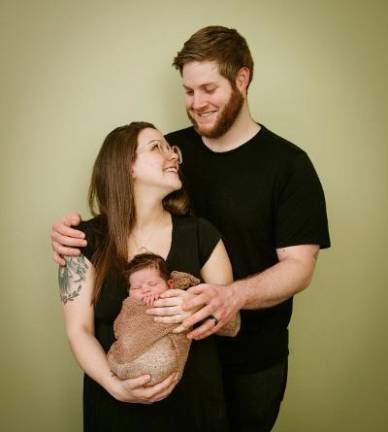 Bare Necessities owner Mikaela Turner is shown with her husband, Jake, and their child.