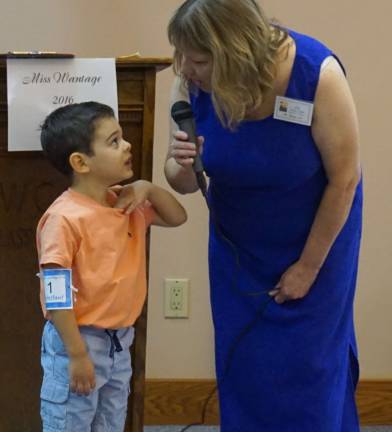 PHOTOS BY VERA OLINSKI Lorenzo Blanco, left, talks to Mistress of Ceremonies Cindy Zajac, right, about orange.