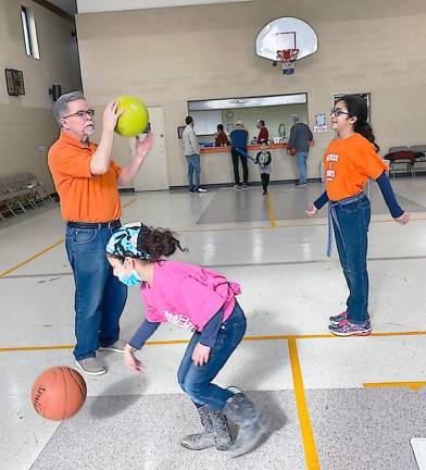 Kevin Carr, director of Outreach Sports for Kids, interacts with Annabella and Elora Marquina during the beginning of last Saturday's session (Photo by Laurie Gordon)