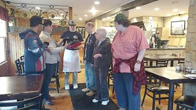 John’s of Arthur Avenue is a community-minded restaurant. This photo from 2017 shows owner Colin Smith distributing tee shirts to visitors from Devereux Tristate Adult Day Care, who were treated to lunch and some pizza-making tips (File photo by Anya Tikka)