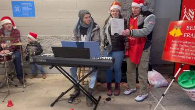 Volunteers sing carols outside the Walmart in Franklin before Christmas as they collect donations for the Bells of Franklin charity. From left are Robert Ernst of the Franklin Band with his son Samuel; Ian Scott and his wife, Kaylee; and Bill Truran. (Photo courtesy of Bill Truran)