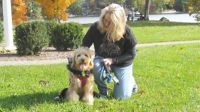 Pet owner Angela Garofalo straightens Ernie's skunk costume (Photo by Janet Redyke)